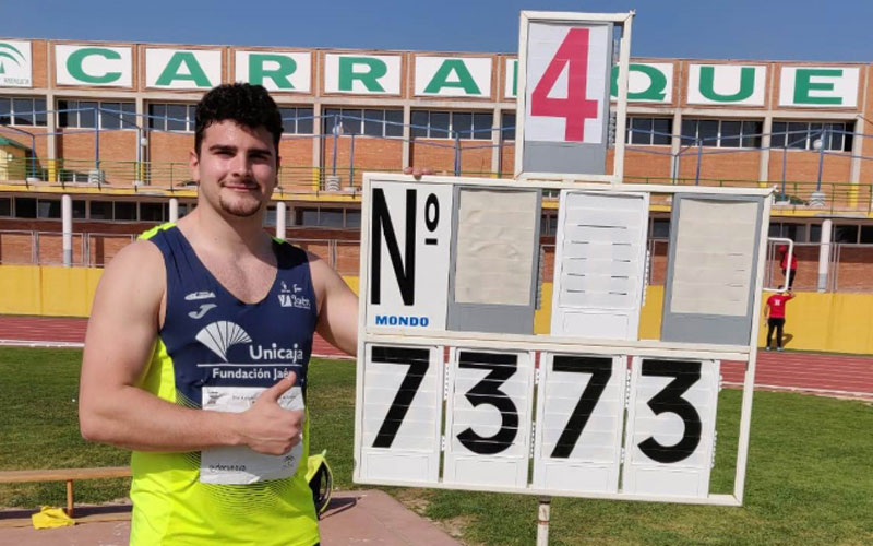 Alberto González, del Unicaja Atletismo, junto al marcador con el récord de Andalucía de martillo 