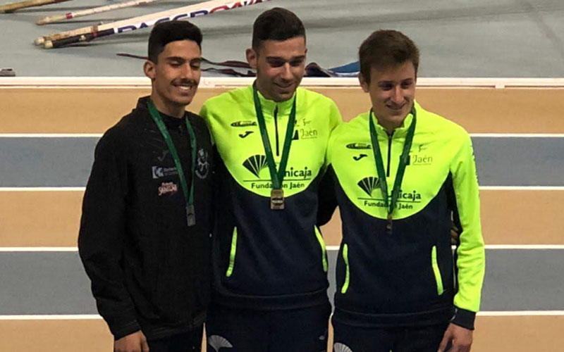 Tres atletas en el podio con sus medallas de ganadores