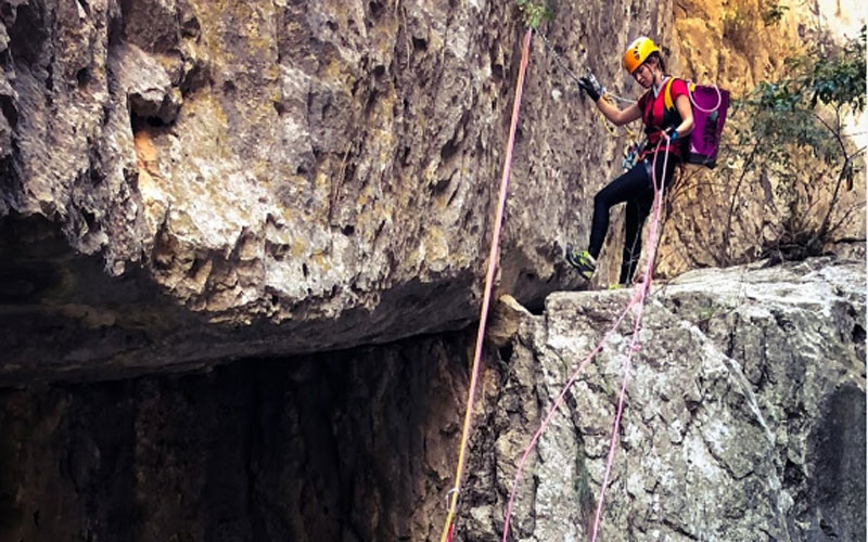 Una chica realizando técnicas de espeleología