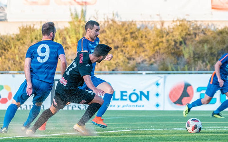 Un jugador del Porcuna pelea un balón en el partido ante el Ciudad de Lucena