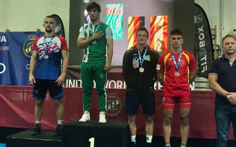 Luchadores reciben sus medallas en el podio