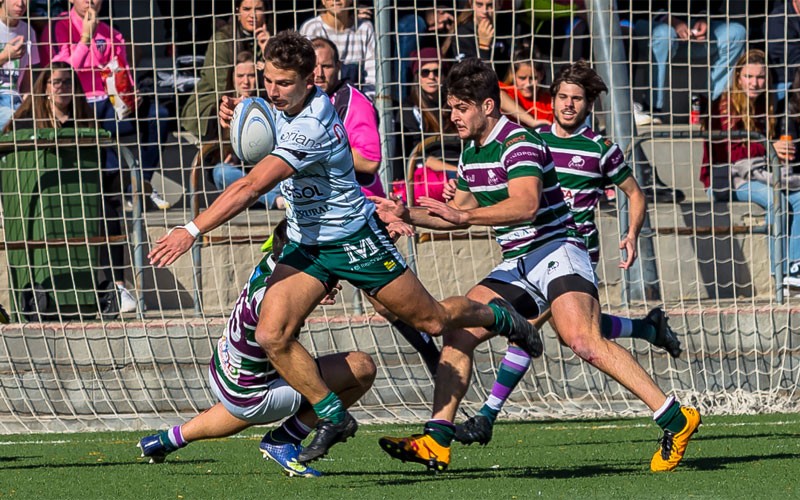 Un jugador del Jaén Rugby esquivando un placaje de un jugador de CR Málaga