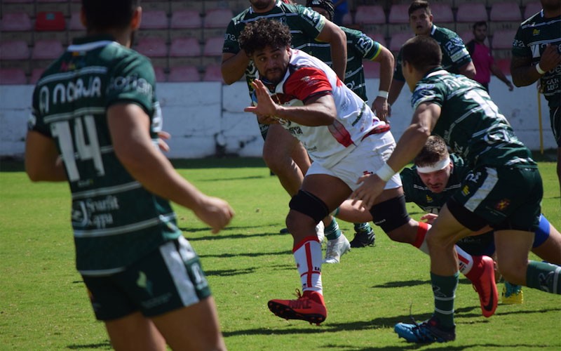 Un jugador de UR Almería presionado por jugadores de Jaén Rugby