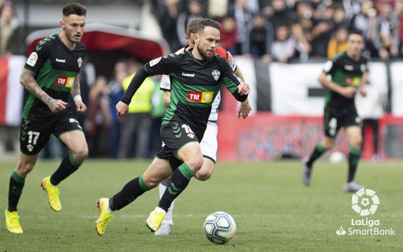 iván sánchez conduce la pelota en un partido con el elche